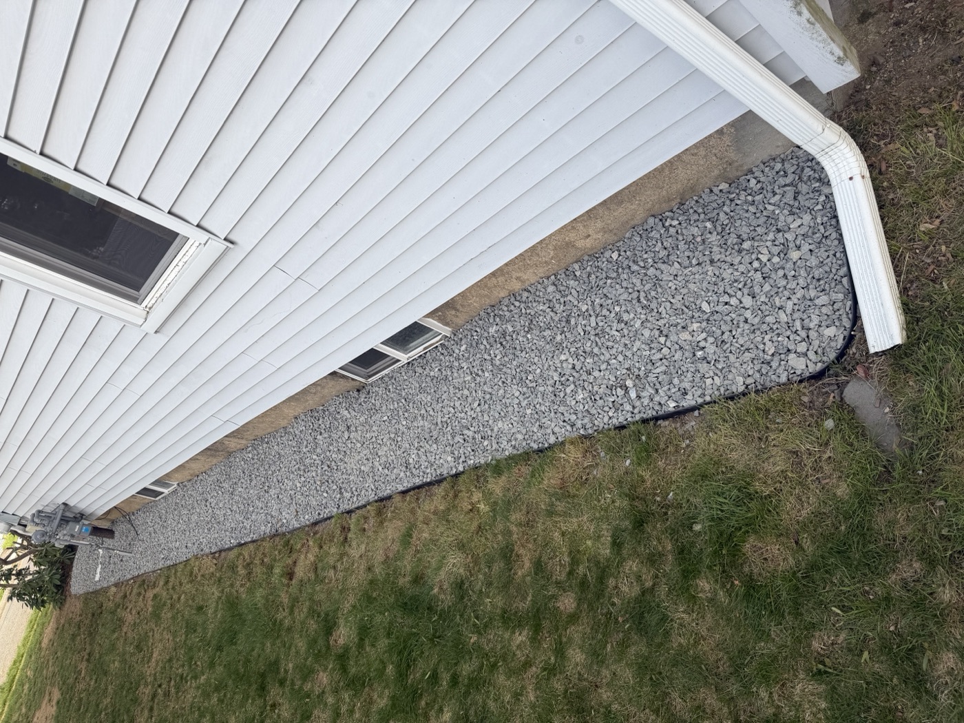 Professional crushed stone drainage bed installed along home foundation in MetroWest MA