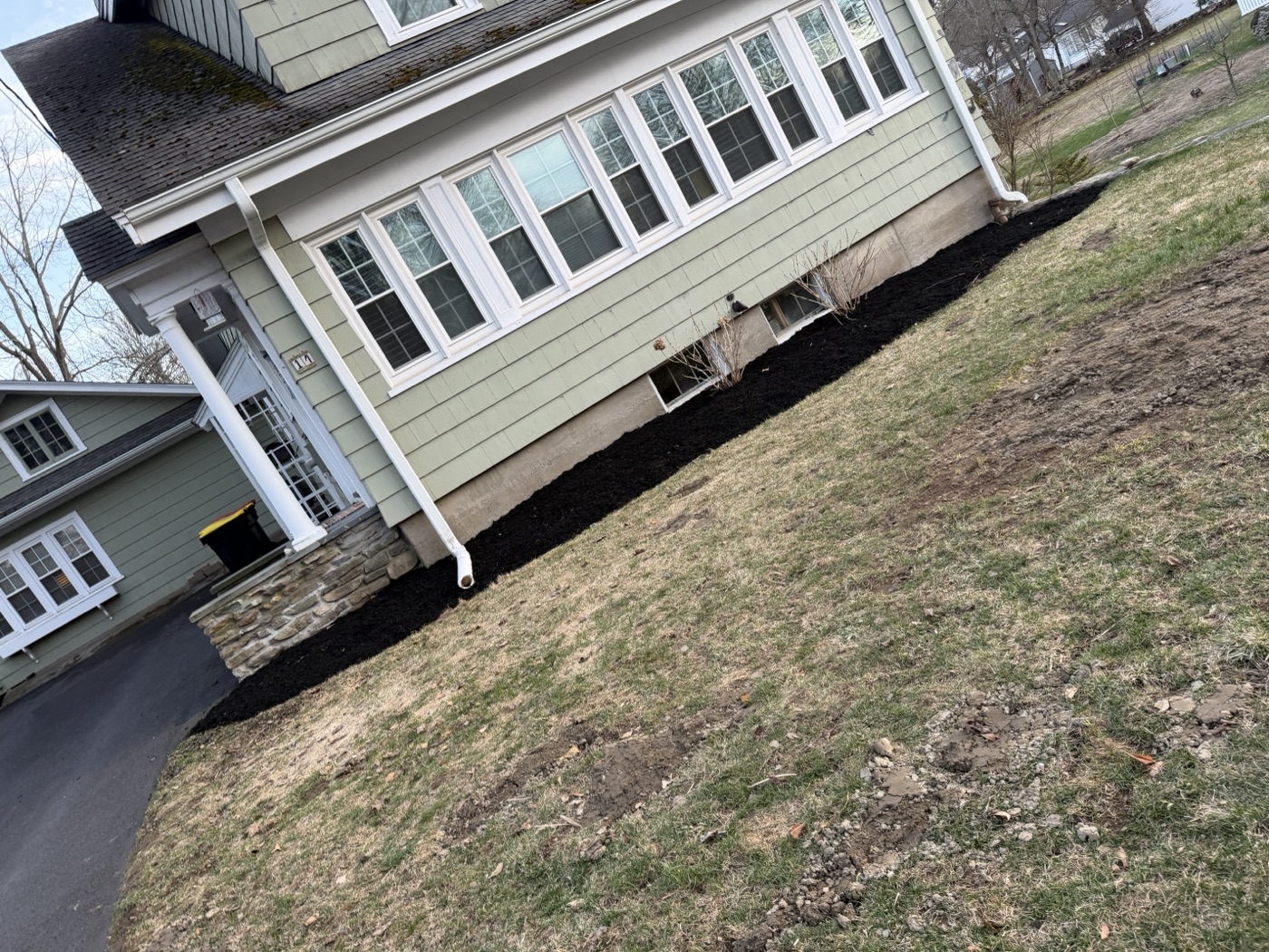 Fresh black mulch bed installed along home foundation by TB Lawn and Landscape in MetroWest MA